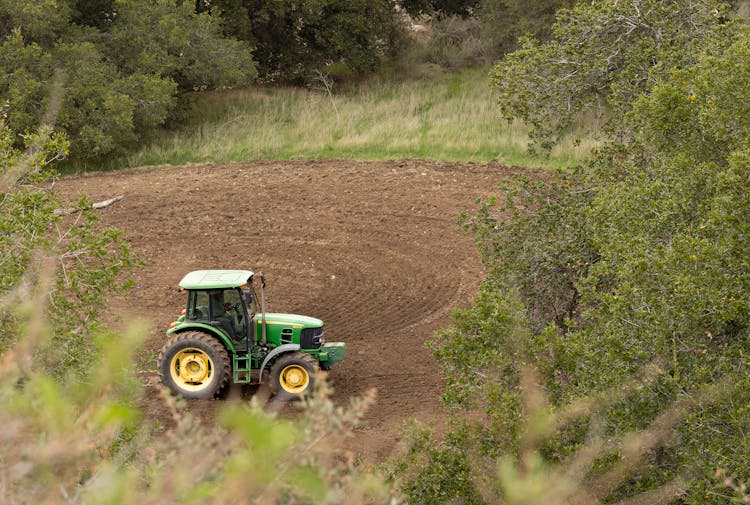 A Tractor Plowing On The Field