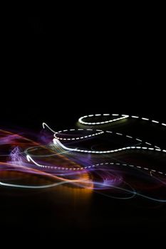 Vibrant abstract light trails with colorful patterns against a black background.