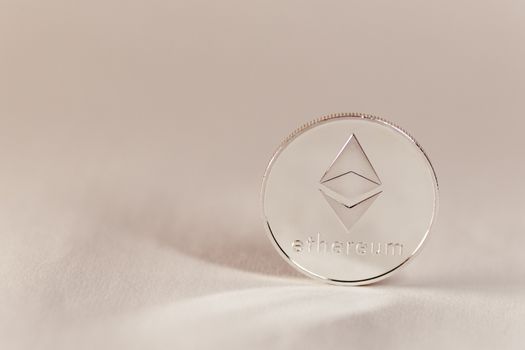 Close-up of an Ethereum coin on a soft, neutral background symbolizing modern cryptocurrency.
