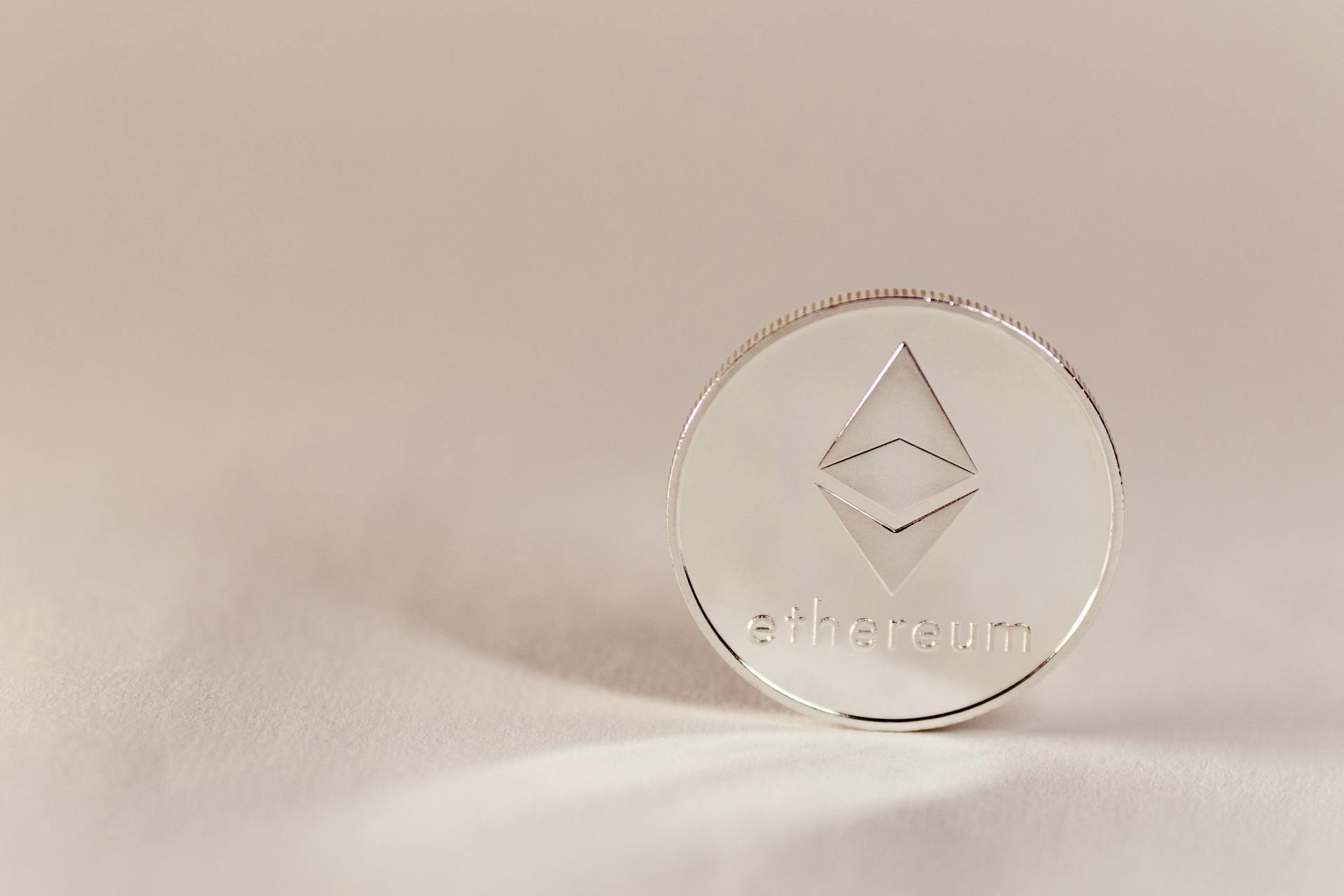 Close-up of an Ethereum coin on a soft, neutral background symbolizing modern cryptocurrency.