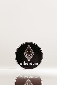 Close-up of an Ethereum cryptocurrency coin with a minimalist design on a reflective surface.