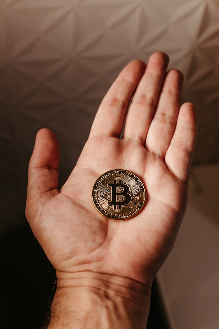 Close Up Of Bitcoin Crypto Currency Coin On Hand