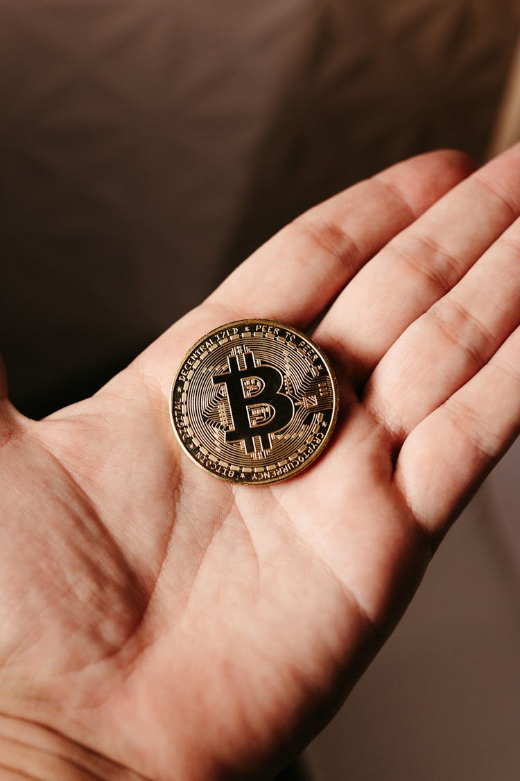 Close Up Of Bitcoin Crypto Currency Coin On Hand