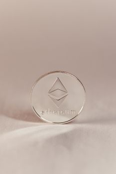A silver Ethereum coin standing upright, symbolizing cryptocurrency and modern finance.