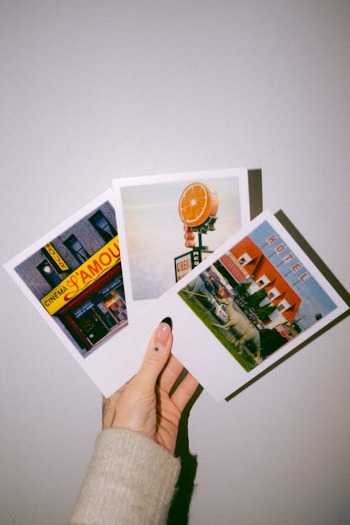 Close-up of Woman Holding Polaroid Pictures 