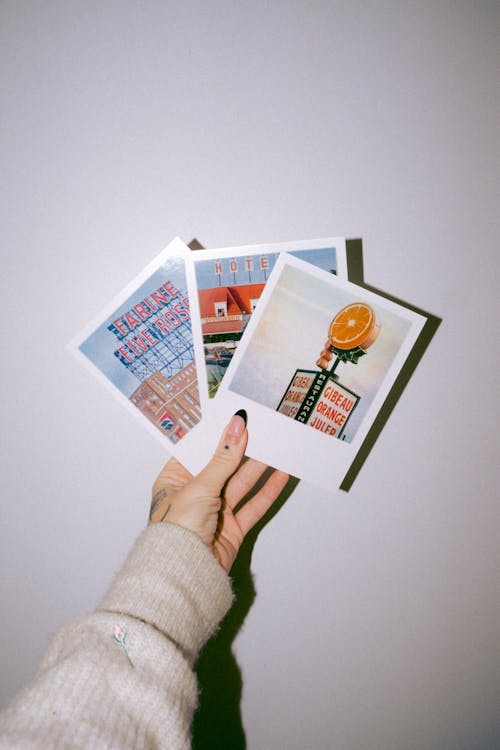 Close-up of Woman Holding Polaroid Pictures 