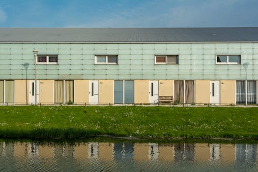 Modern row houses in Den Haag reflecting in a canal on a sunny day.