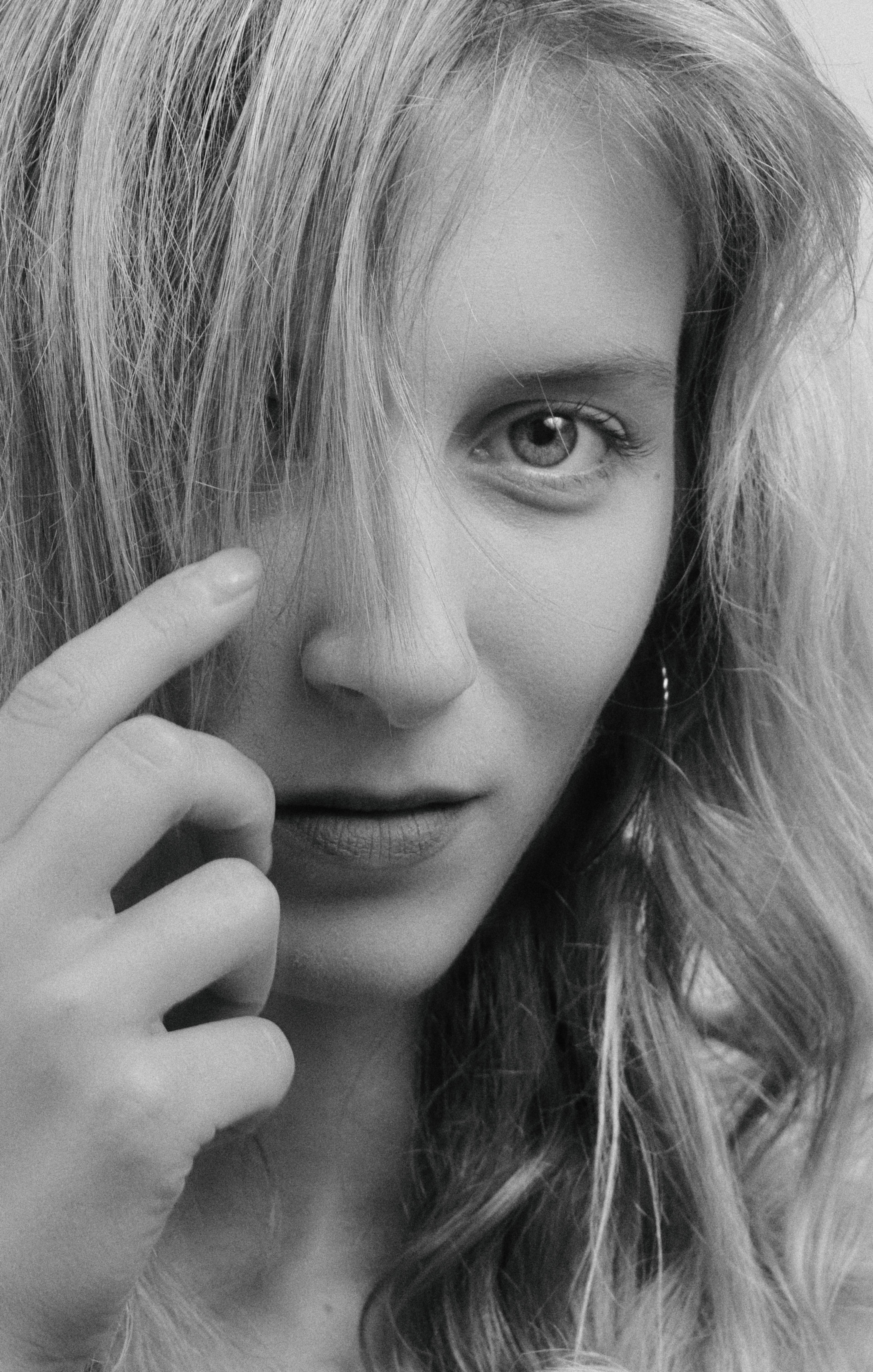 Close-up black and white portrait of a woman with long hair, expressive eyes.