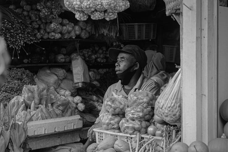 Grayscale Photo Of Man Selling Vegetables