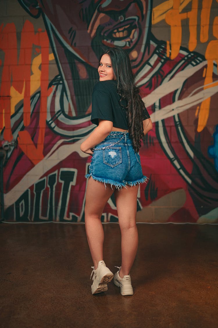 A Woman In A Crop Top Looking Over Her Shoulder 