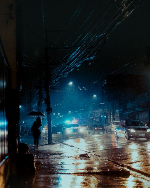 Free Urban scene of a city street at night during rain with visible traffic and reflections. Stock Photo