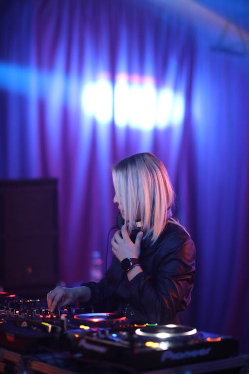 Woman DJ Working on an Audio Mixer