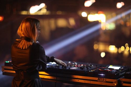 Free A young female DJ skillfully mixing tracks in a lively nightclub scene, showcasing music and nightlife vibes. Stock Photo
