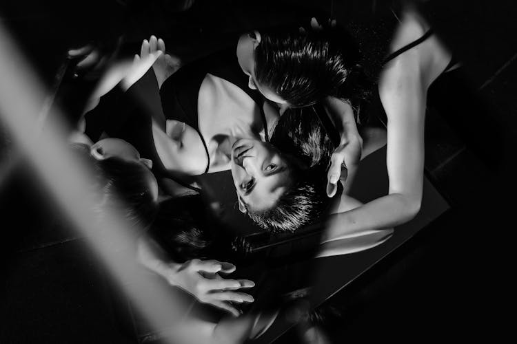 Multiple Exposure Black And White Picture Of A Woman Lying On A Mirror 