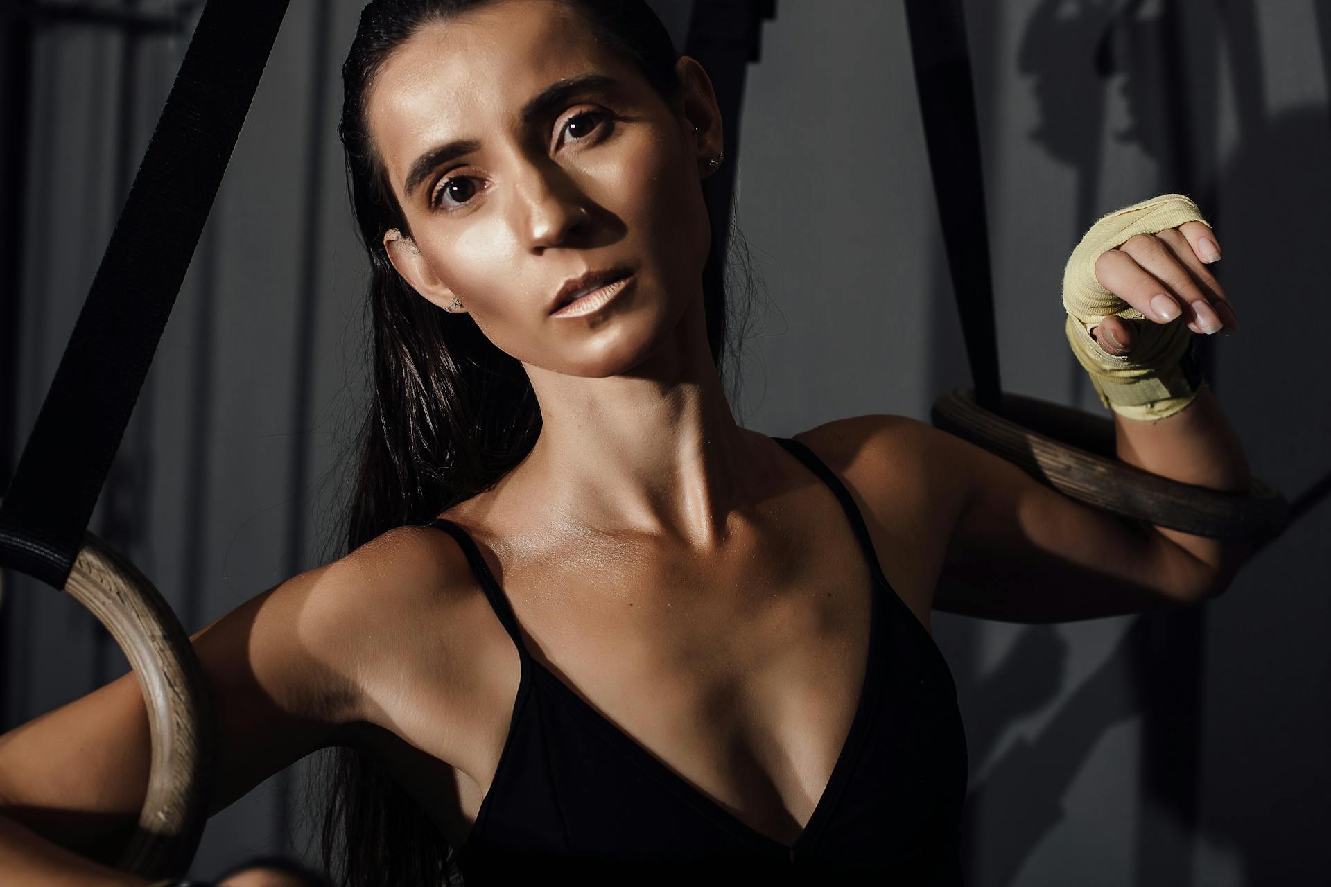 Portrait of a Pretty Brunette Leaning on Gymnastic Rings