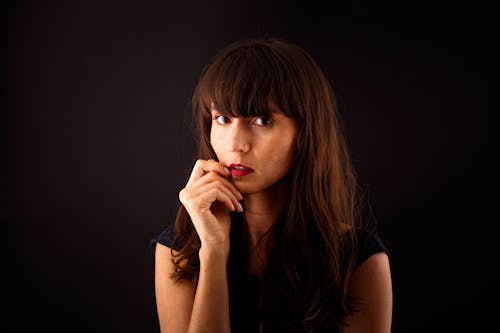 Portrait of a Pretty Brunette Standing against a Black Background