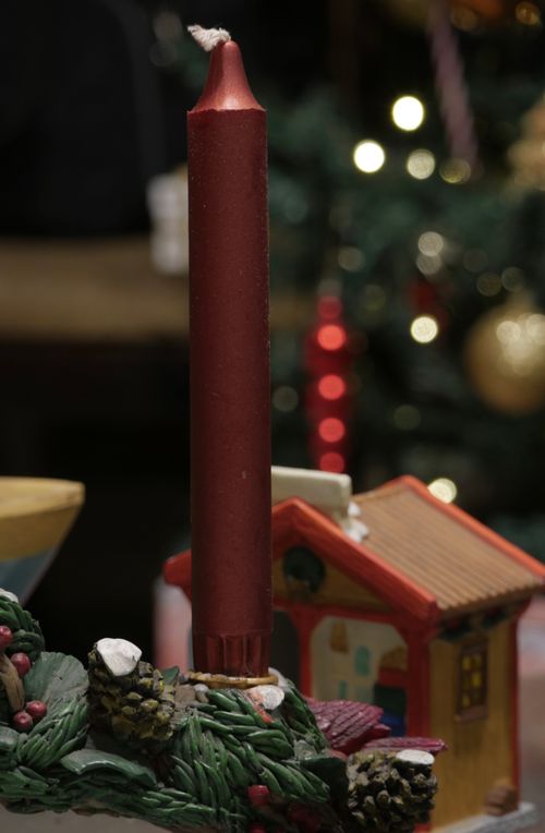 Free Elegant red candle set against a blurred Christmas tree, perfect for holiday decor themes. Stock Photo