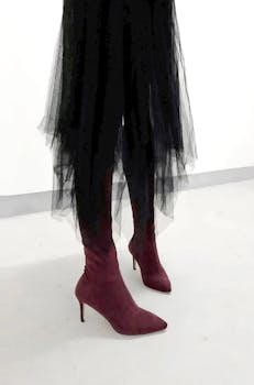 Stylish burgundy high heels paired with a black tulle skirt, showcasing modern elegance.