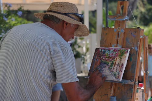 Man in Brown Hat Doing a Painting 