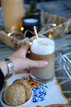 A refreshing latte and cookies on an embroidered napkin, perfect breakfast moment.