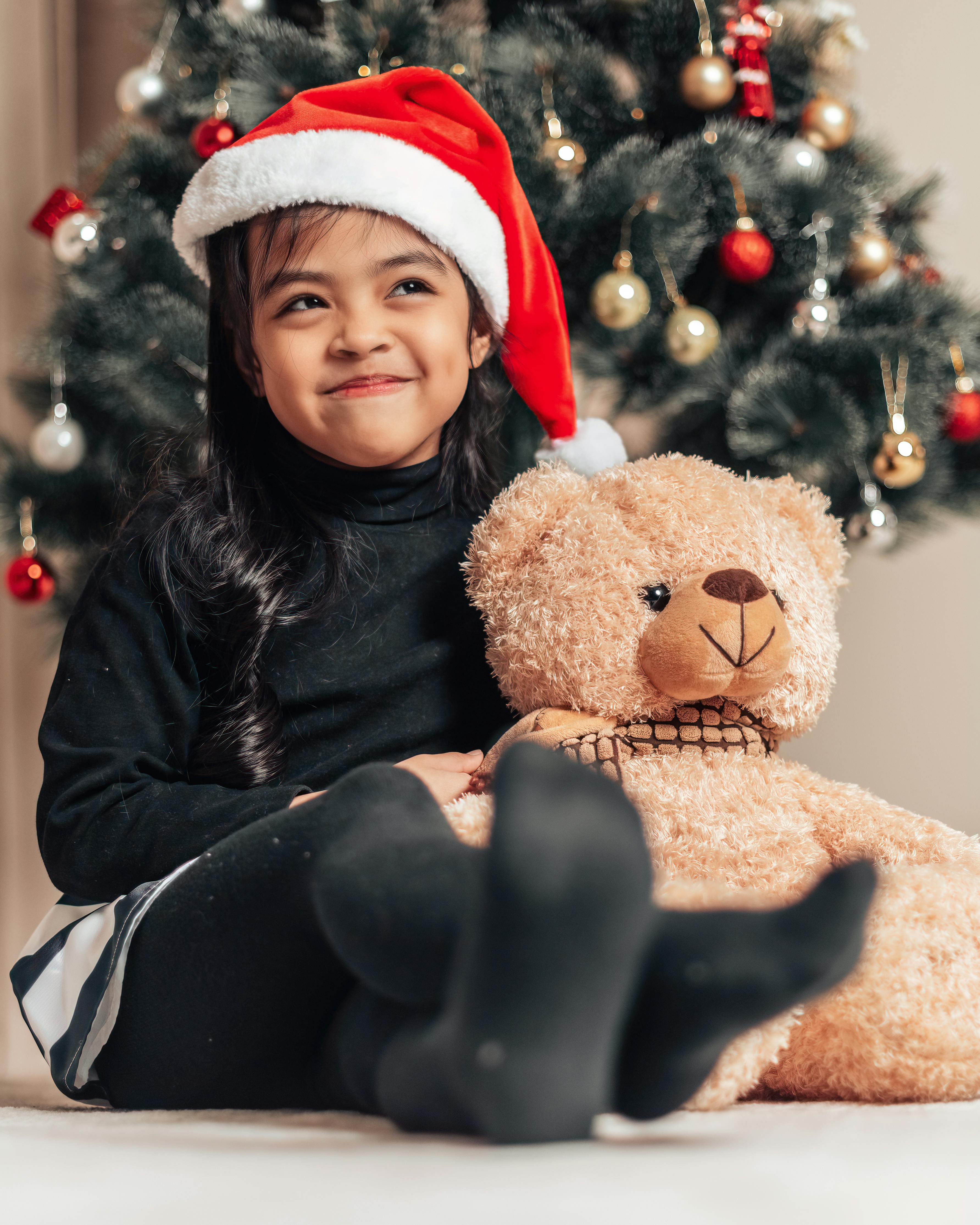 a girl in black sweater wearing santa hat