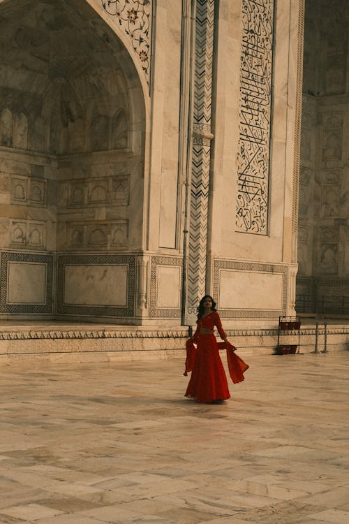 A Woman in Red Saree Standing in Taj Mahal