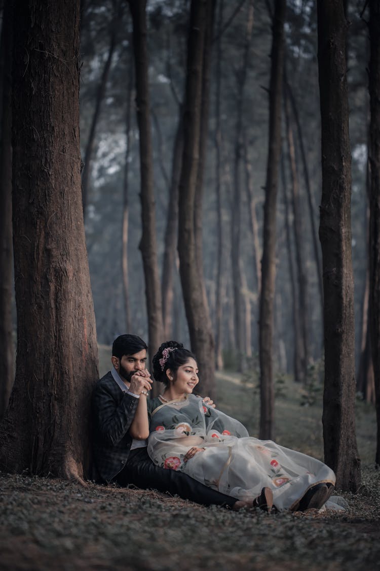 Man Kissing The Woman's Hand White Sitting Under The Tree 