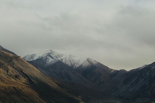 Free A breathtaking view of snowcapped mountains under an overcast sky, exemplifying nature's beauty. Stock Photo