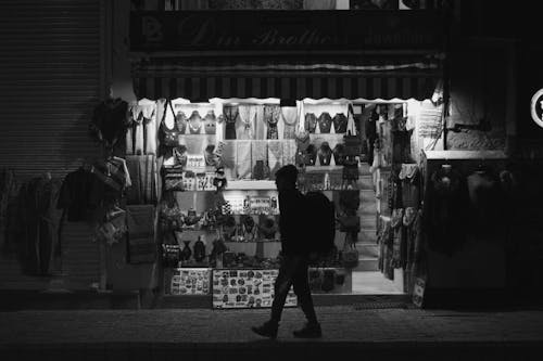 Silhouette of Person Walking in Front of a Store