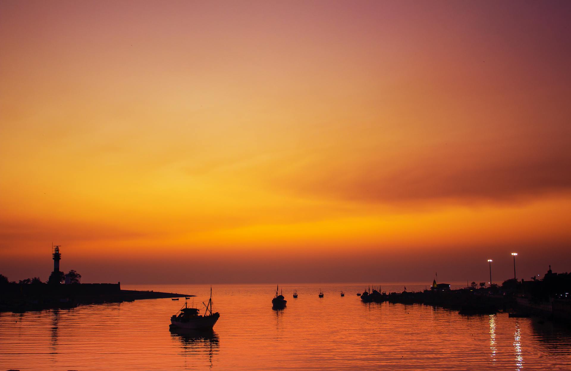 Silhouette of Boats on Sea Near Port Area During Sunset