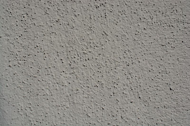 A close-up view showcasing the intricate texture of a gray stucco wall, perfect for backgrounds.