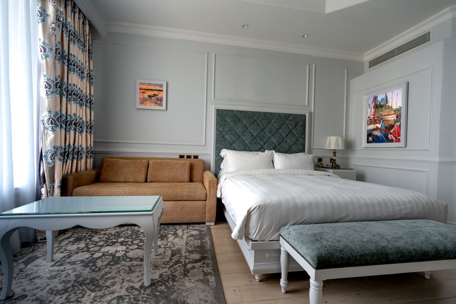 A beautifully designed bedroom featuring a cozy bed, sofa, and chic decor.