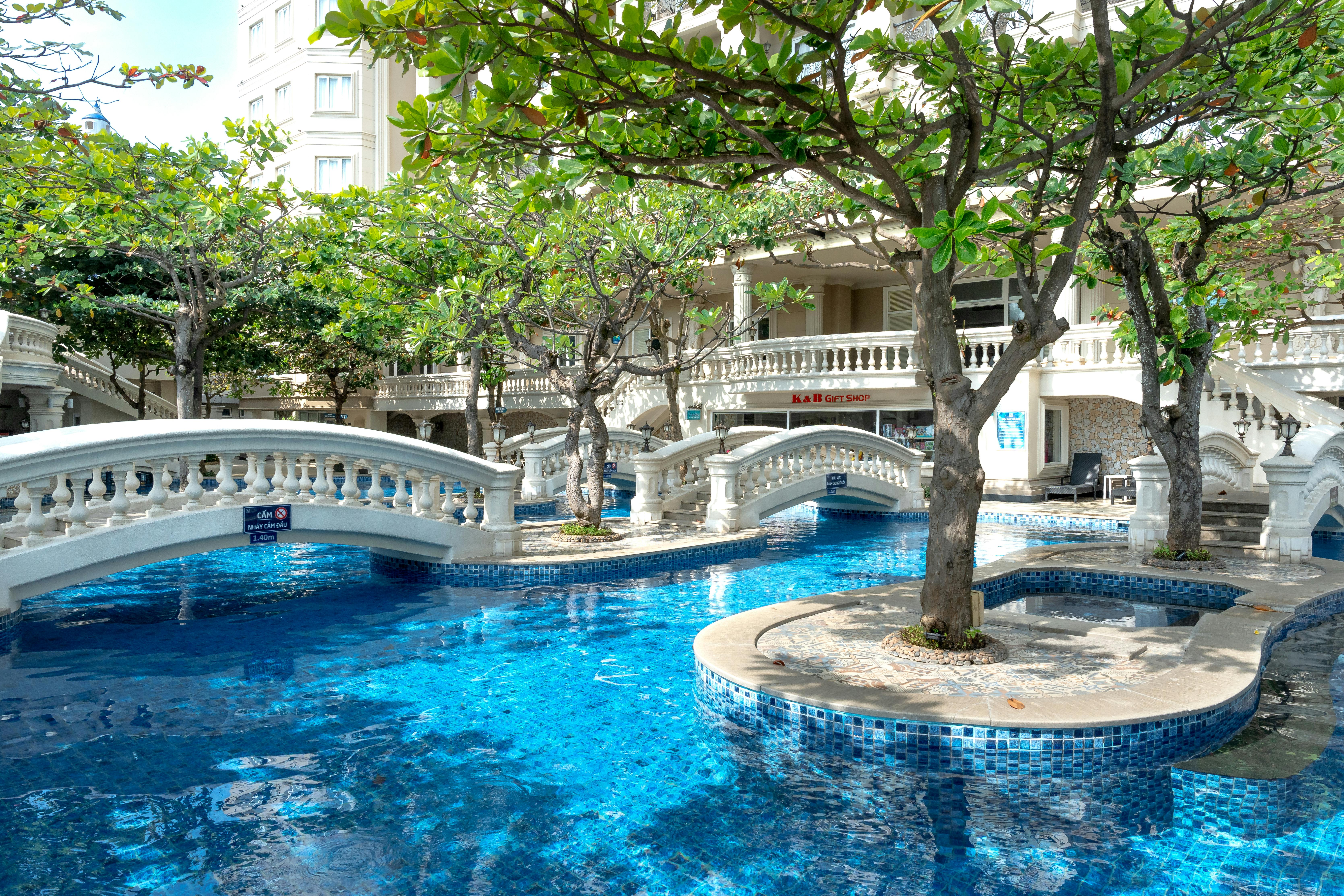 Arch Bridges on a Swimming Pool Under Trees Near a Building · Free