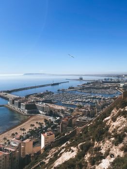 Stunning aerial view of Alicante harbor by the Mediterranean Sea under a clear blue sky.