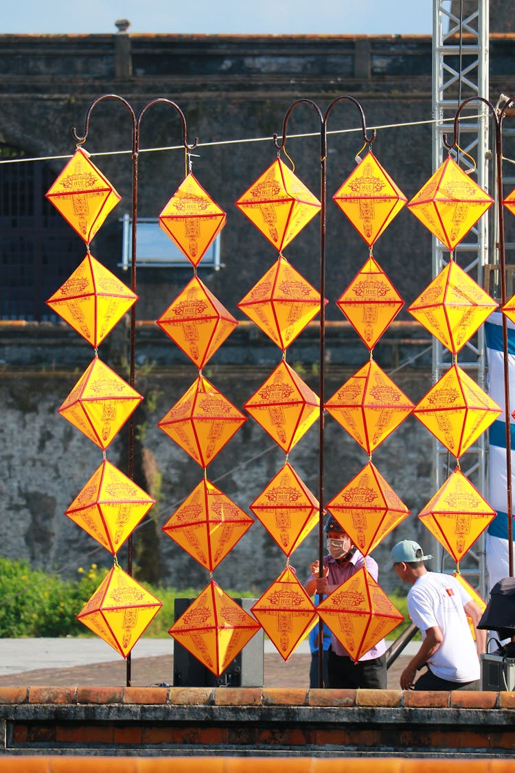 Men Arranging Vietnamese Lanterns Outside The Street