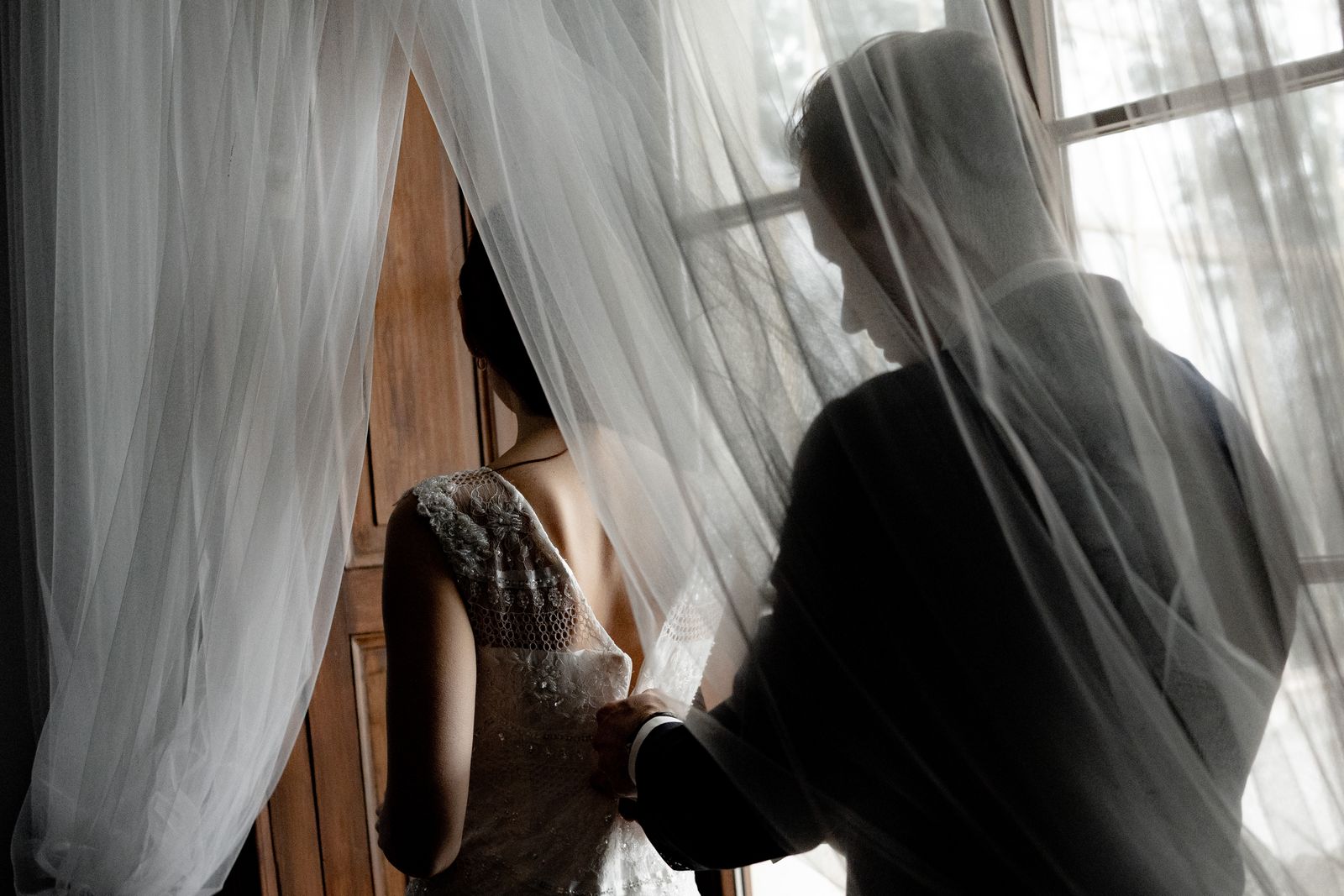 Wedding couple preparing together near a window