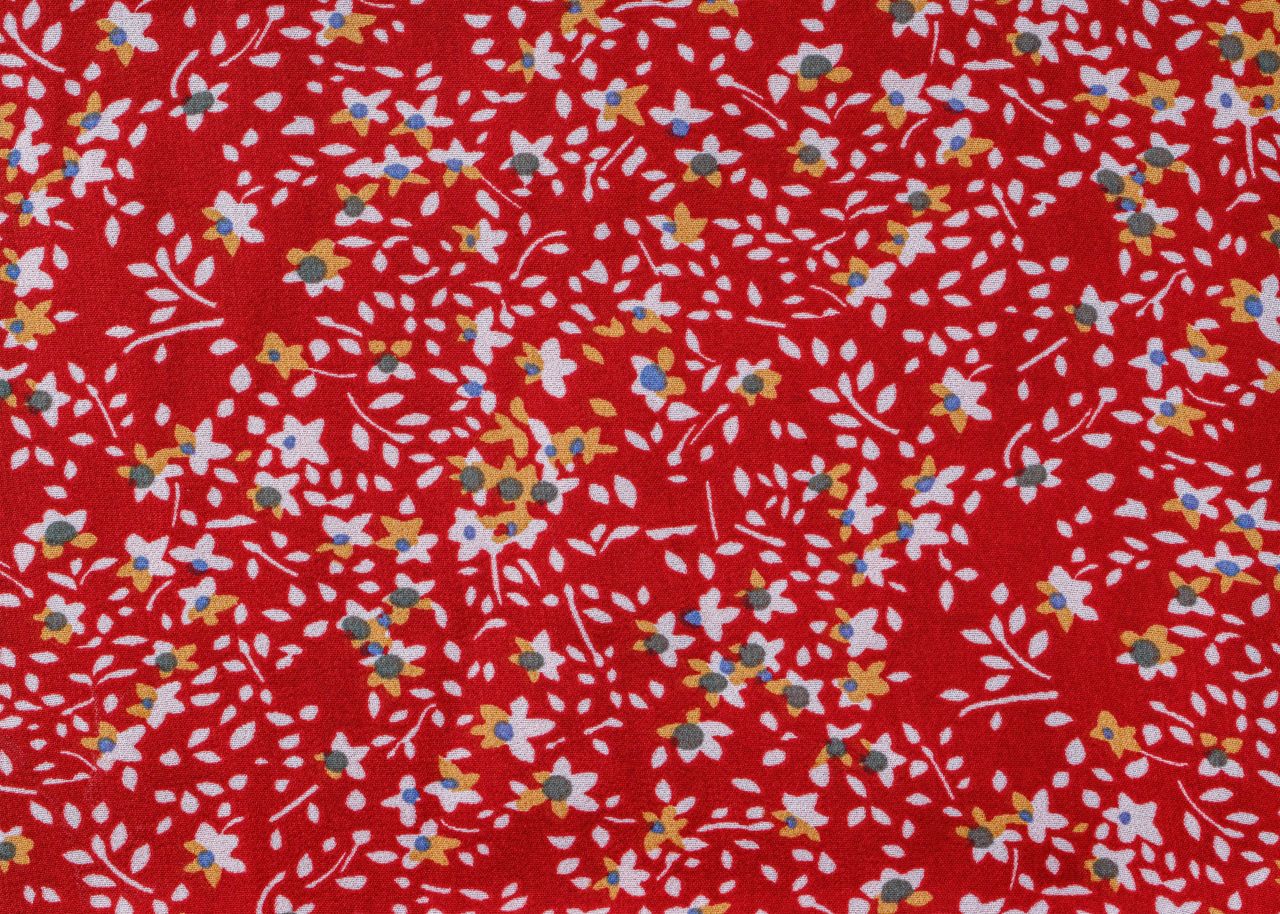 colorful floral pattern featuring small flowers on a vivid red fabric