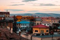 A picturesque urban cityscape in Romania showcasing rooftops against a stunning sunset backdrop.
