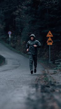 Fitness enthusiast running on a forest road in camouflage clothing, conveying solitude and focus.