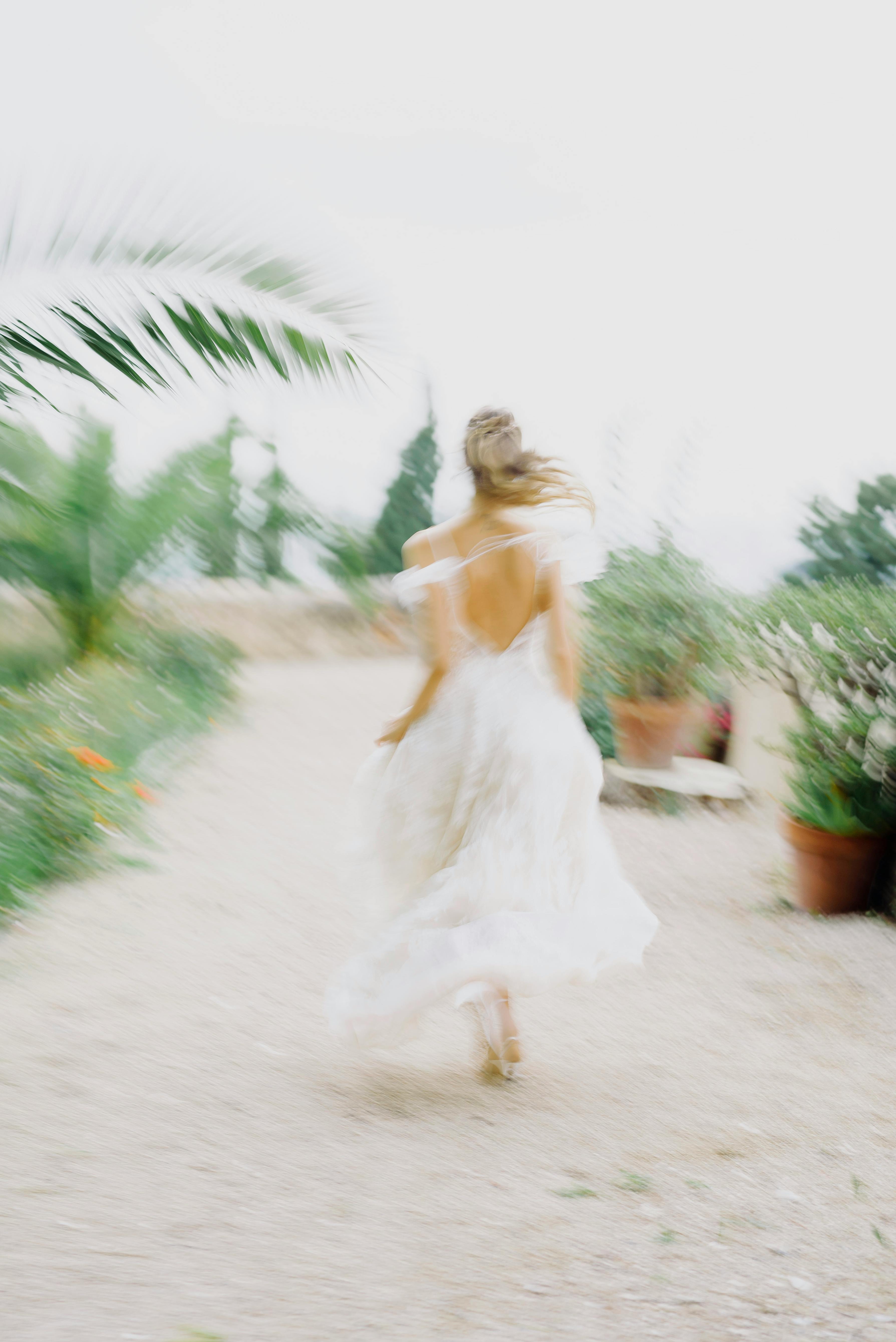 blurred woman running in white dress