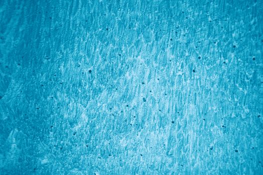 A detailed close-up of a blue textured wall with rough surface patterns perfect for design backgrounds.