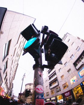 Dynamic city street view captured with fish-eye lens emphasizing urban architecture and traffic signal.
