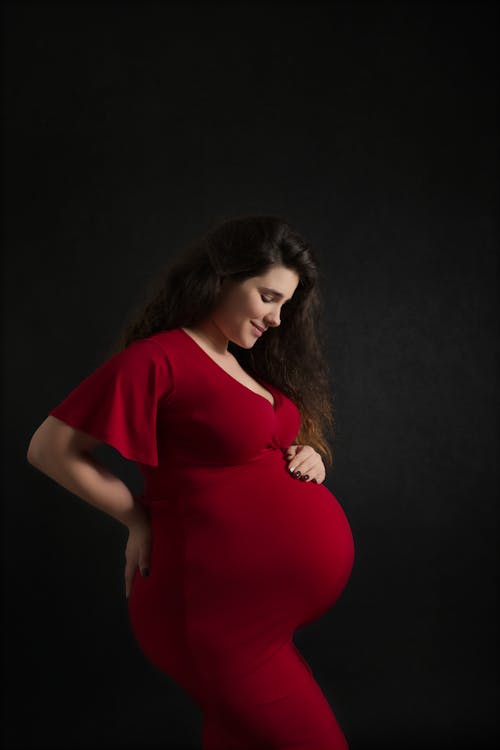Free A Pregnant Woman in a Red Dress Stock Photo