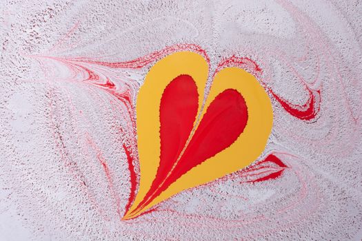 Vibrant abstract painting with a heart shape in red and yellow on a swirling background.