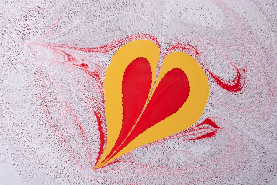 Vibrant abstract painting with a heart shape in red and yellow on a swirling background.