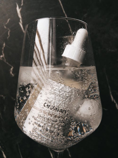 Bottle of a Beauty Product in a Glass of Water 