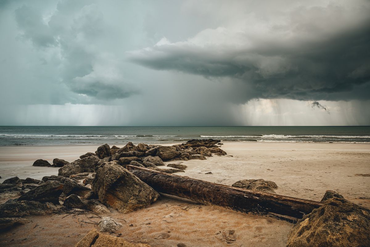 Storm clouds and rain moving in over a beach, the kind of forecast that can cause a hurricane delay on moving day