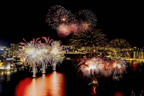 Fireworks Exploding over a Coastal City at Night