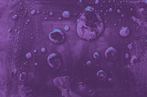 Close-up of Liquid Drops on a Purple Surface