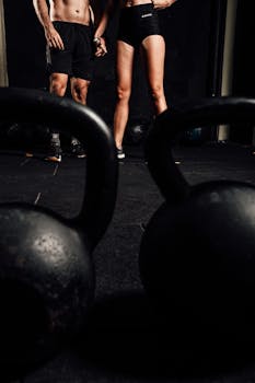 Man and woman in gym with kettlebells, embracing a healthy lifestyle.